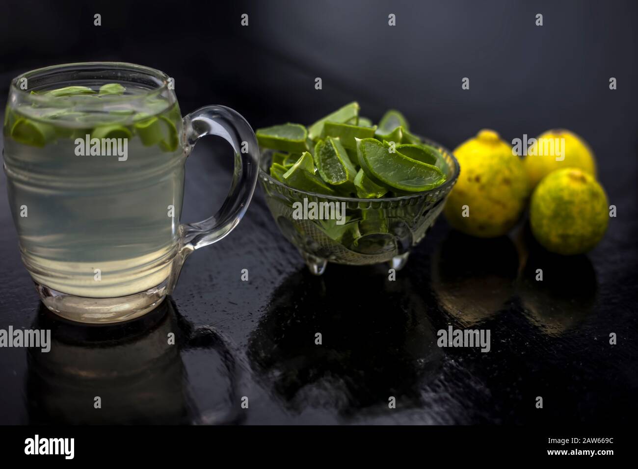 Close up of glass mug sur la surface en bois contenant de l'aloe vera et le jus de citron boisson detox avec l'ensemble de ses ingrédients de base avec elle. Sho horizontale Banque D'Images