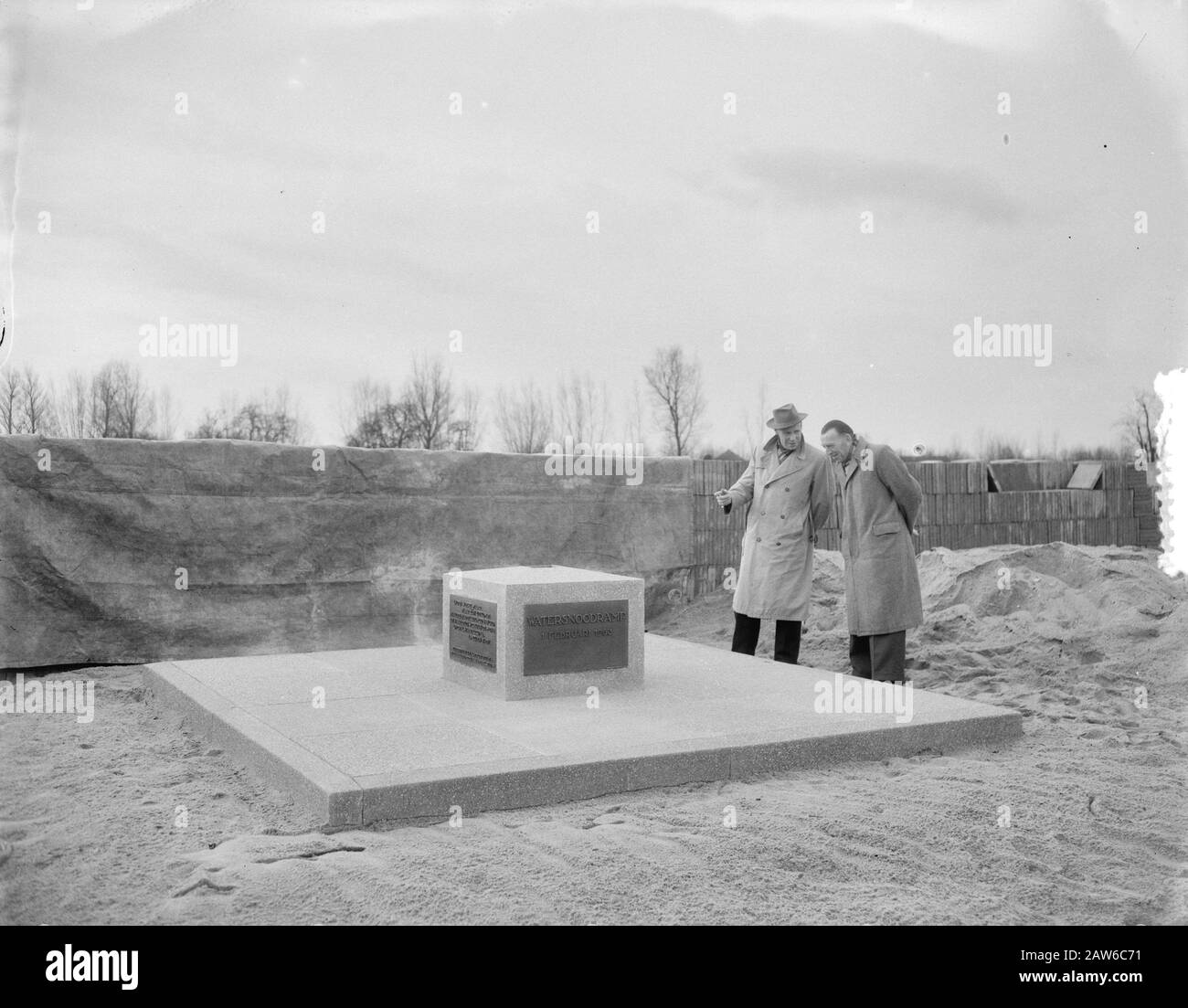 Mémorial Des Catastrophes Pour New Vossemeer. Ce monument, que la société d'adoption qui a effectué le site de réparation à l'église a été donné le 1er février 1954 sera dévoilé par le commissaire de la Reine en Angleterre. La croix de pierre est de 3,62 m de haut et le sokker 3:50 mètres carrés. Les plaques de bronze sont également laissées le passage final du discours de la Reine le 8 février '53, au milieu des mots Flood le 1er février 1953 et à gauche le 12ème verset de l'hymne national. Le maire de New Vossemeer E.P.A.M. Janssens (à droite) et M. B. J. Hoogsteden, qui placent le monument (à gauche), ont visité le à N.V. Verwo Banque D'Images