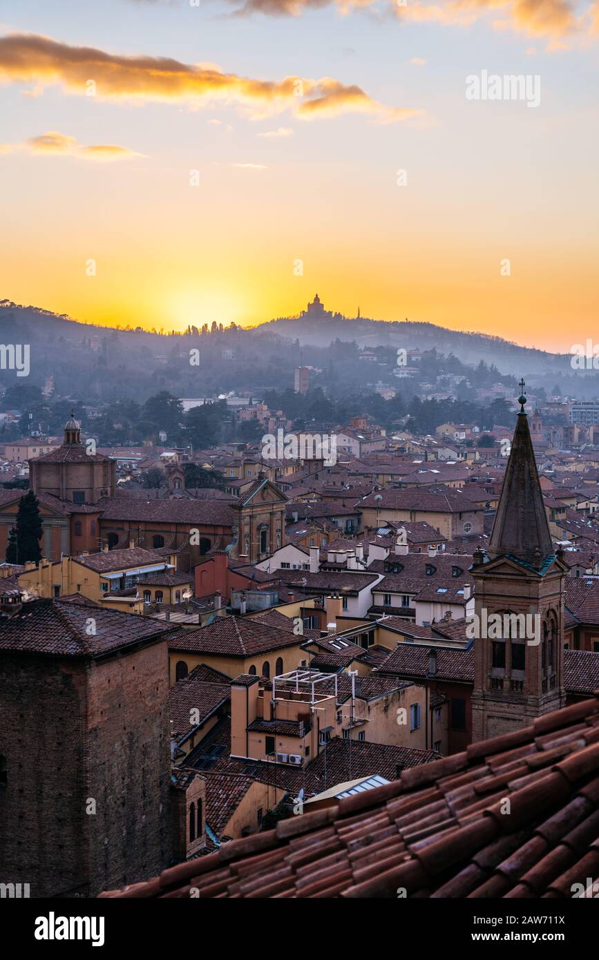 Coucher de soleil à Bologne, vue aérienne sur les toits et la colline avec le monastère de San Luca. Banque D'Images