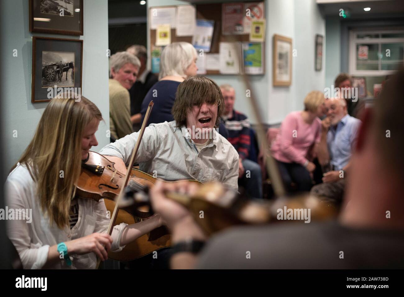 Les habitants de la région jouent pendant une séance de musique à l'hôtel Colonsay sur l'île de Colonsay, sur la côte ouest de l'Écosse. L'île est située dans la zone du conseil d'Argyll et de Bute et a une superficie de 4 074 hectares (15,7 miles carrés). Aligné sur un axe sud-ouest à nord-est, il mesure 13 km de long et atteint 4,8 km à son point le plus large, en 2019 il comptait 136 adultes et enfants. Banque D'Images