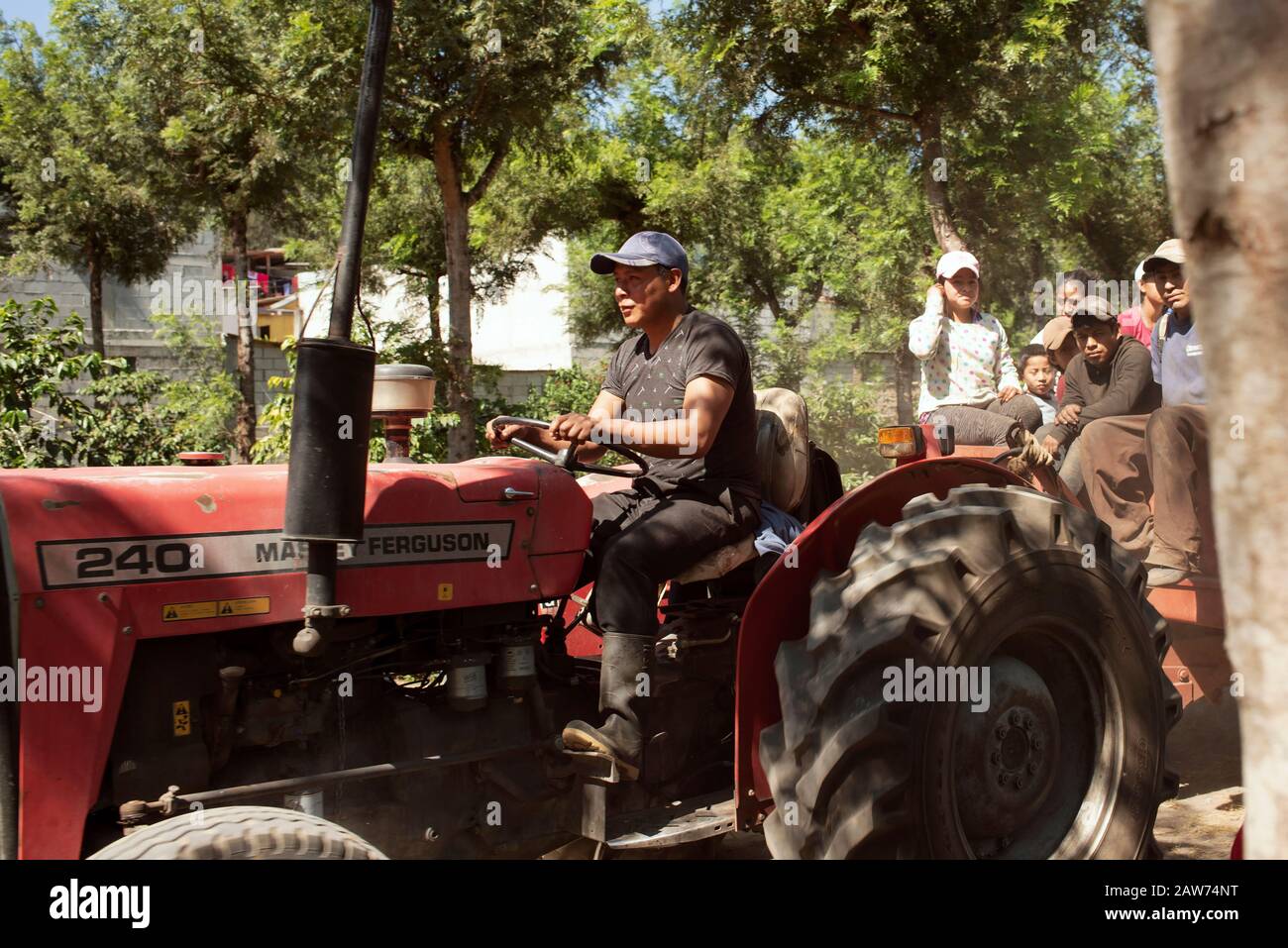 Tracteur avec remorque agricole transportant des guatémaltèques en service. Dans les coulisses d'une plantation de café sur la rue San Lazaro, Antigua, Guatemala. Janvier 2019 Banque D'Images