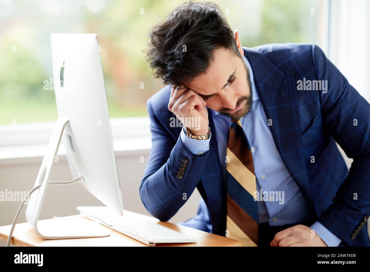 Homme assis à l'ordinateur réfléchi Banque D'Images