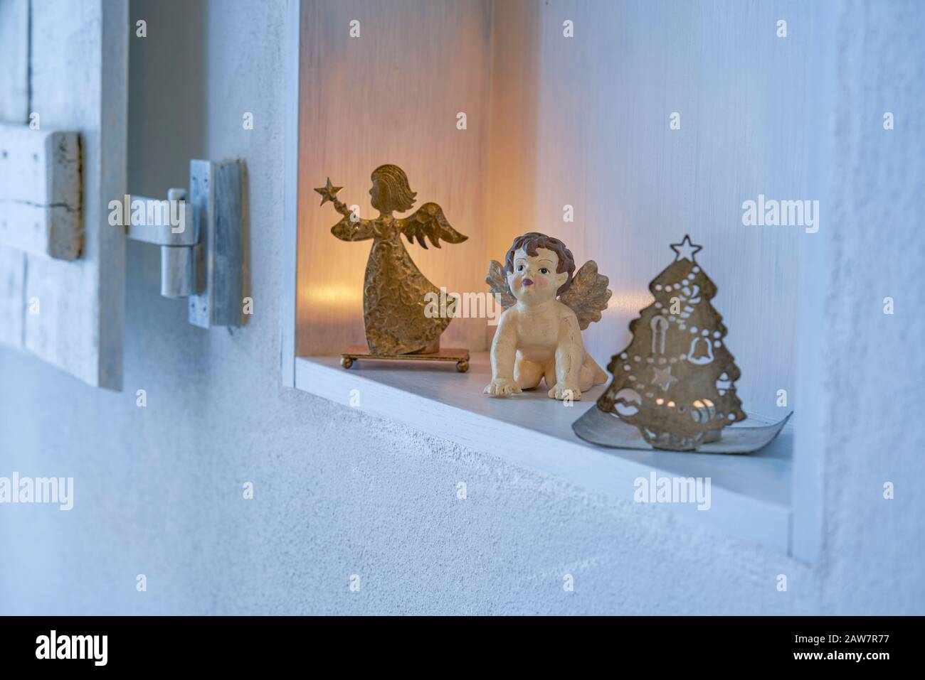 Décoration de Noël avec anges et bougies dans un rayon blanc pur dans un mur blanc, l'or argent brillant humeur pour carte de célébration Banque D'Images
