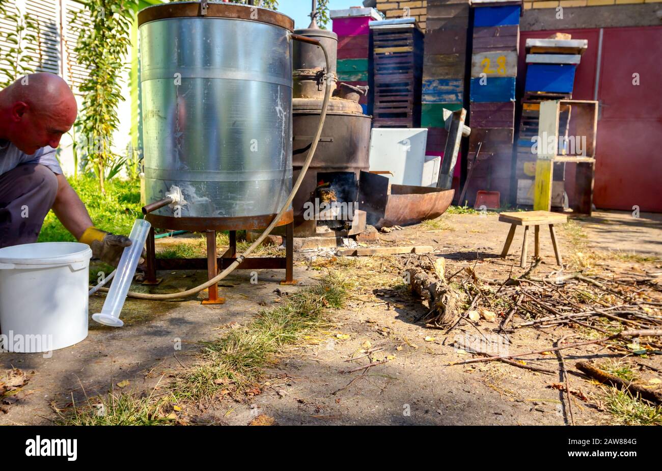 L'homme prend un échantillon de liqueur fraîchement distillée, alcool dans le cylindre gradué de laboratoire. Banque D'Images