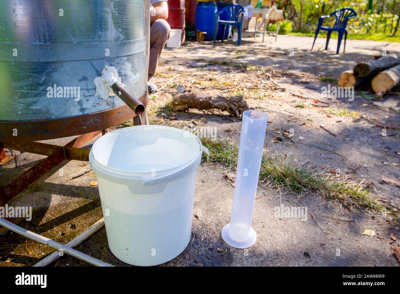 L'homme prend un échantillon de liqueur fraîchement distillée, alcool dans le cylindre gradué de laboratoire. Banque D'Images