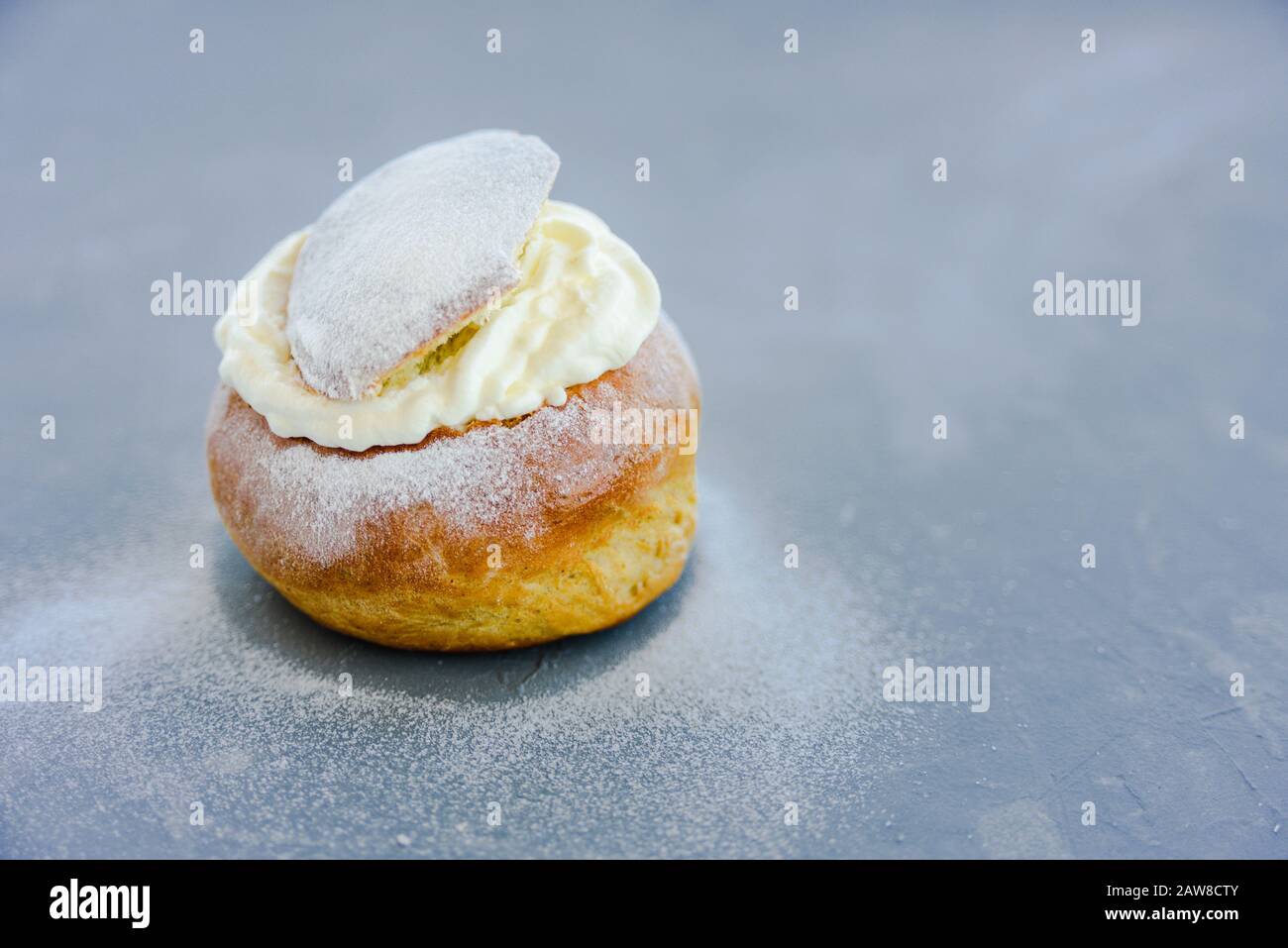 Pain rempli de crème fouettée Semla suédoise sur fond de béton gris. Shrove dessert du mardi Banque D'Images