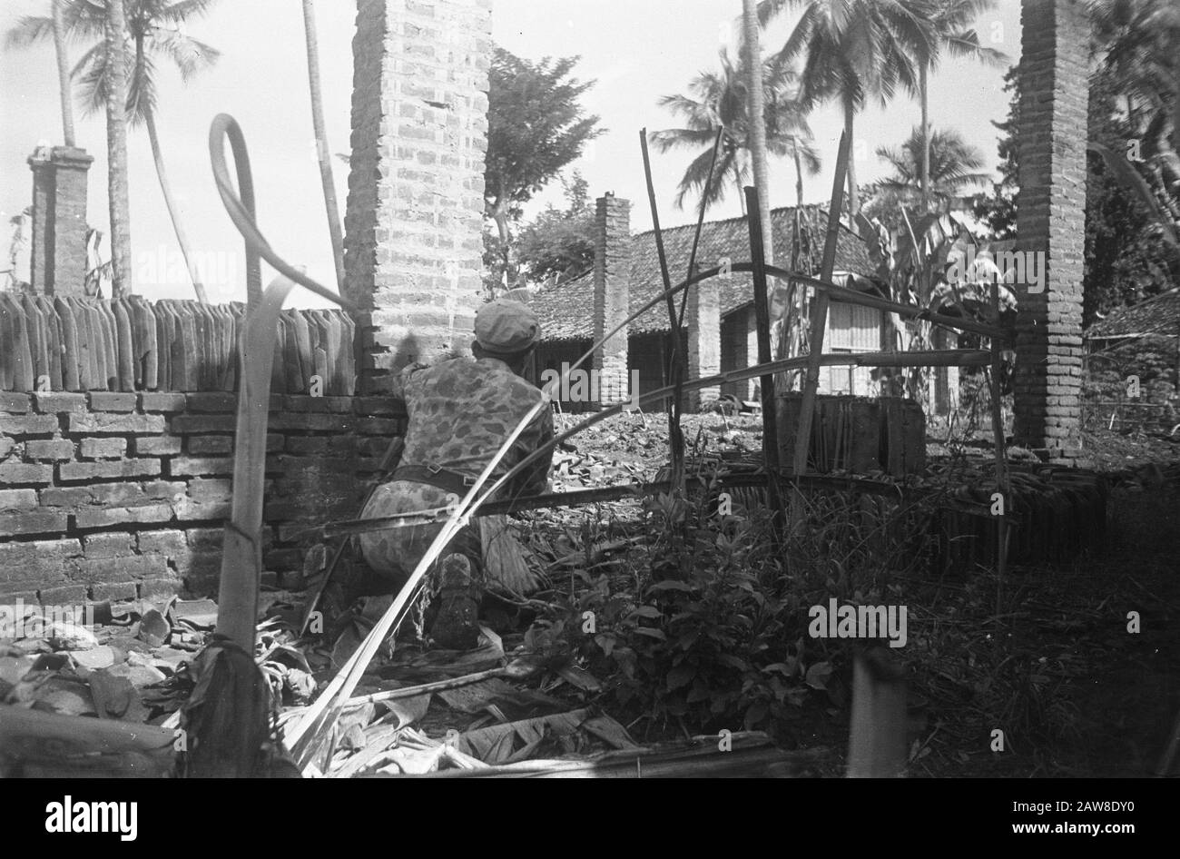 Opération près de Keboemen, Tjilatjap Military cherche une couverture derrière le mur d'une maison ruinée Date: 29 mars 1949 lieu: Indonésie, Java, Hollandais East Indies : Boekholt / DLC Titulaire du droit d'auteur: Archives nationales Type de matériel: Négatif (noir / blanc) numéro d'inventaire: Voir accès 2.24.04.02 Banque D'Images