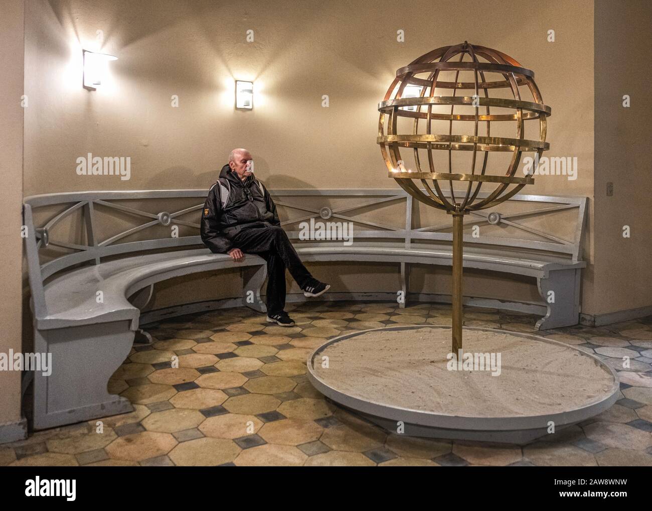 Touriste homme âgé assis à l'intérieur De Vor Fue Kirk. Église notre-Dame - immeuble néoclassique du XIXe siècle à Copenhague, Danemark Banque D'Images