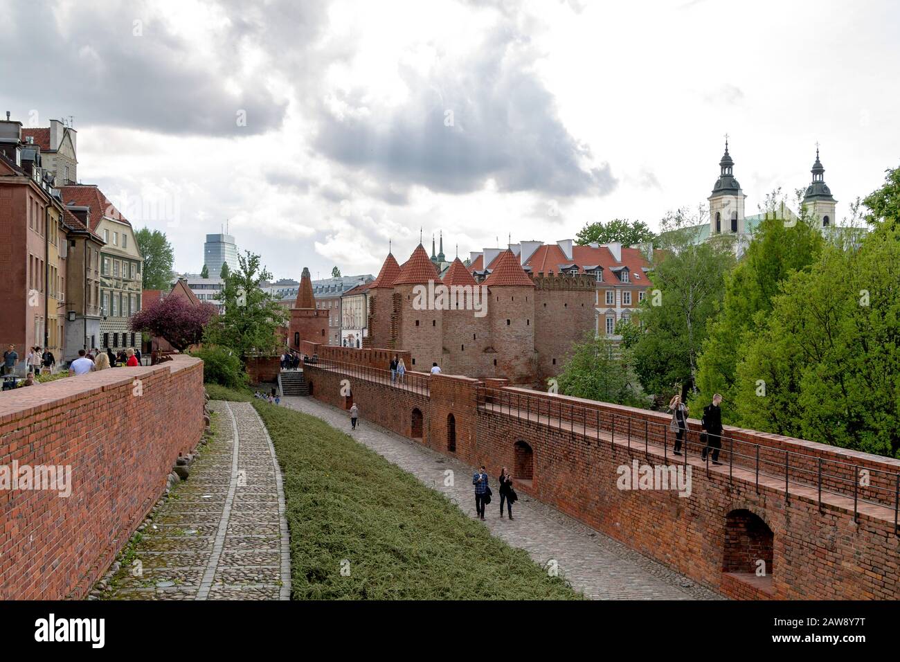 Le people marche sur les murs de briques fortifiés de la vieille ville de Varsovie avec la tour Barbican en vue Banque D'Images