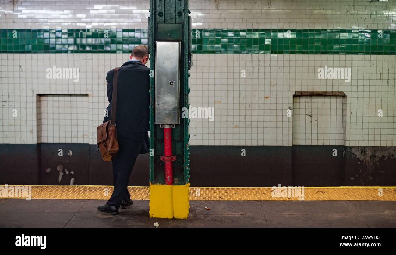 Jeune homme d'affaires à la station de métro arrêt attendant le train. Banque D'Images