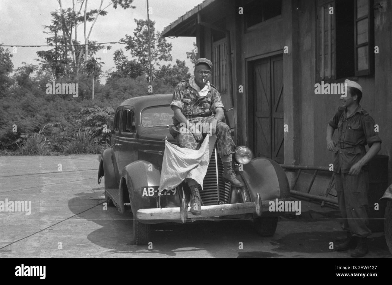 Assis sur le capot de la voiture Banque d'images noir et blanc - Alamy