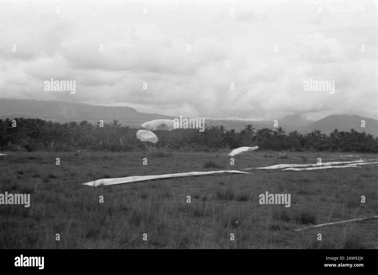 Faites des exercices pour faire tomber les fournitures par avion Parachutes qui descend sur un champ ouvert. But de chute indiqué par des bandes de tissu Date: Novembre 1947 lieu: Indonésie Hollandais East Indies Banque D'Images