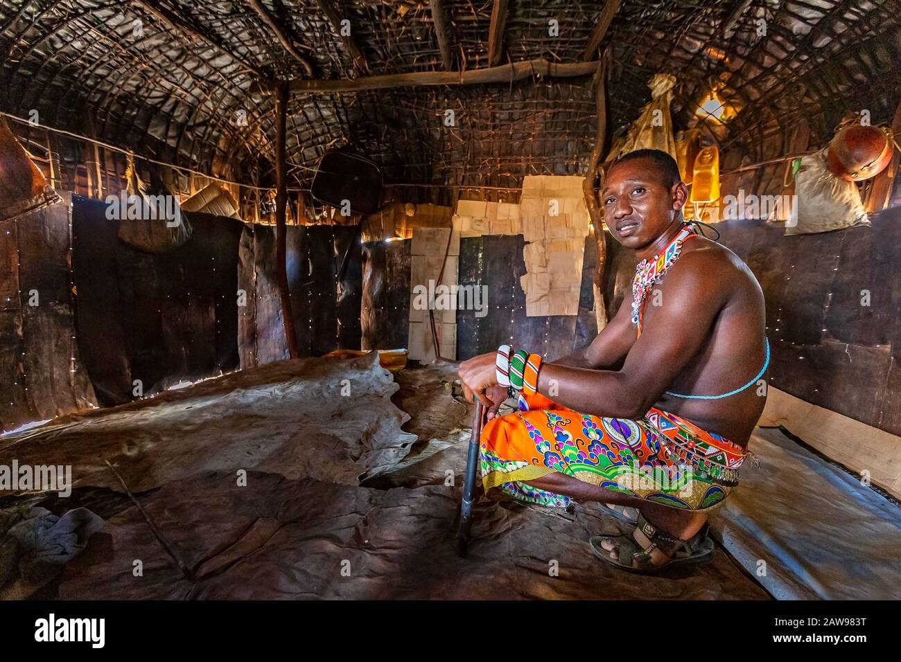 Samburu homme assis à l'intérieur de la maison de village, à Samburu, au Kenya Banque D'Images