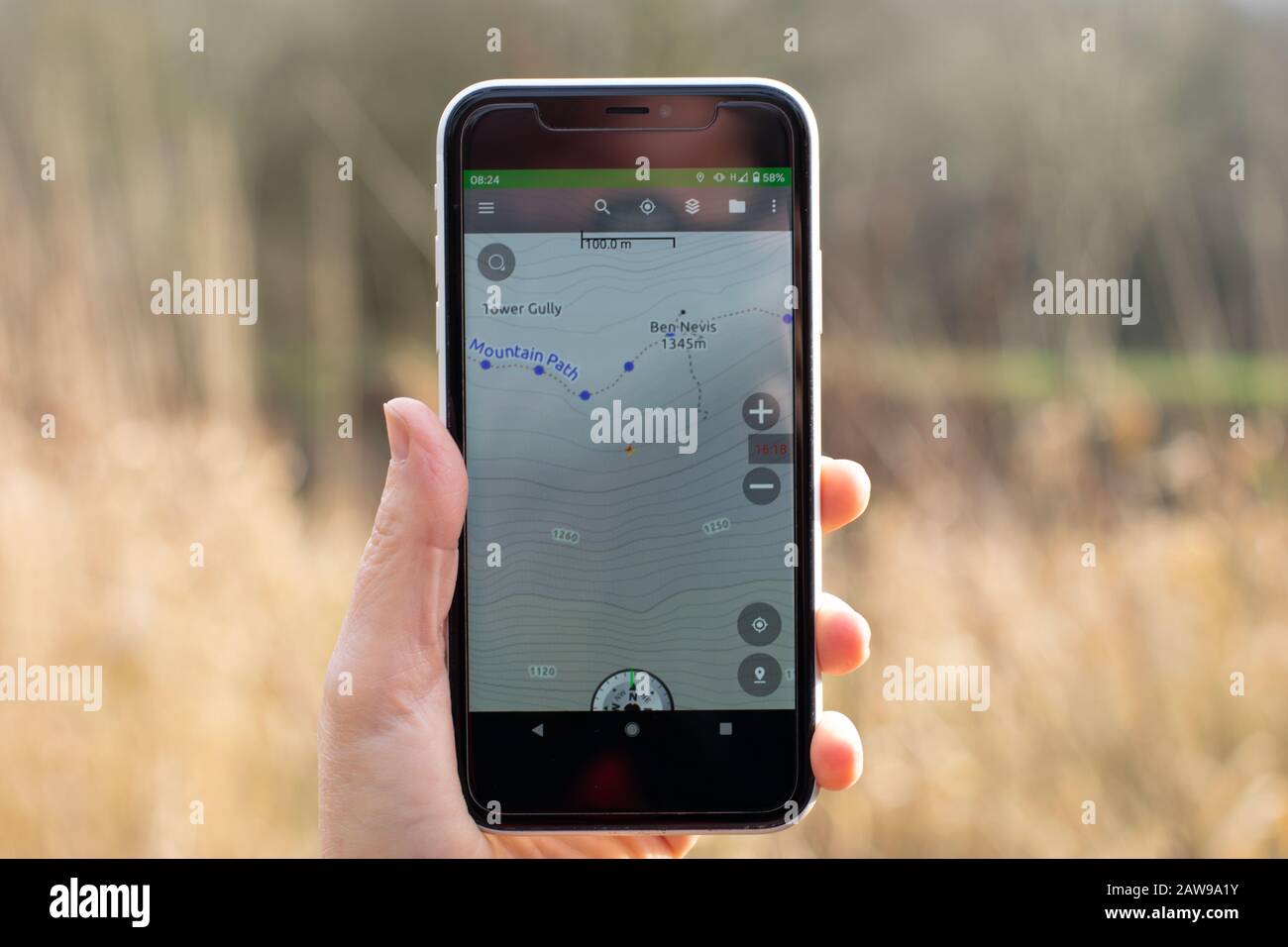 Carte Thunderforest de Ben Nevis affichée sur un téléphone mobile avec herbe d'hiver en arrière-plan Banque D'Images
