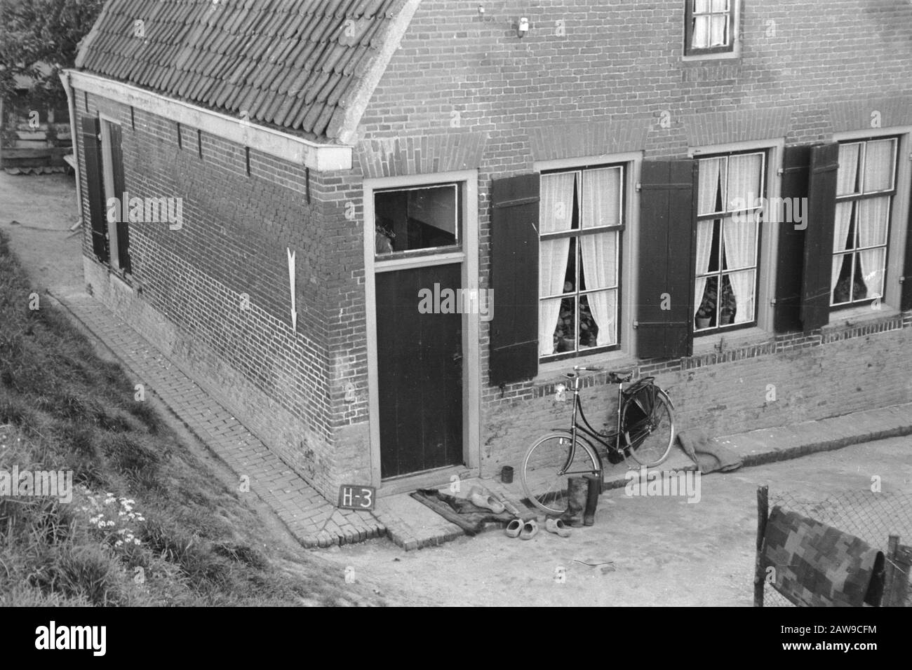 Soutien à la culture bonus fixe Dijkhuis Hagestein (consolidation des  terres Vijfheerenlanden) Annotation: H-4. La flèche pointe vers le point  fixe. Sabots la porte avant, bottes, une robe et un vélo Date: