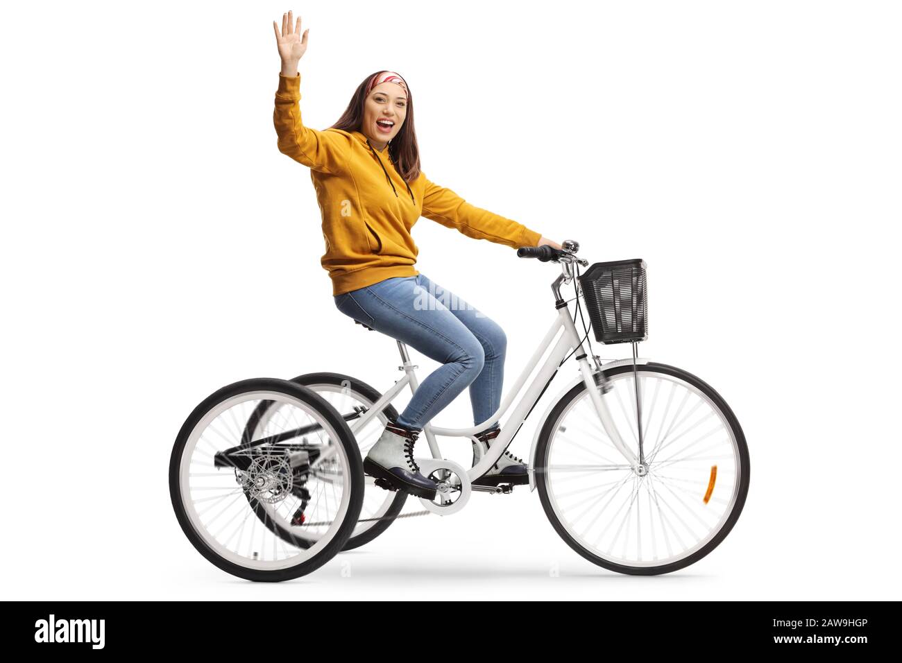 Gai jeune femme qui monte un tricycle et qui agite à la caméra isolée sur fond blanc Banque D'Images