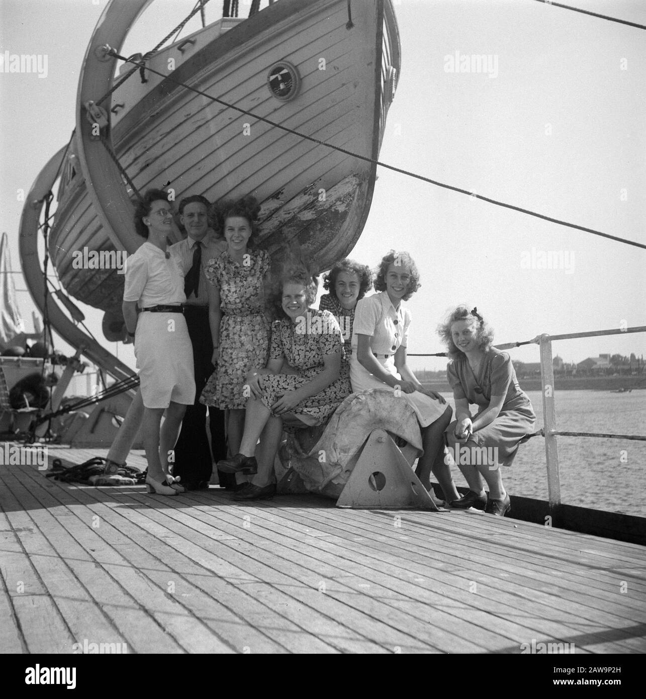 Reportage Vulcan. Un groupe (femmes et un homme) pose sous un bateau de sauvetage Date : 19 septembre 1947 mots clés : rapports Banque D'Images