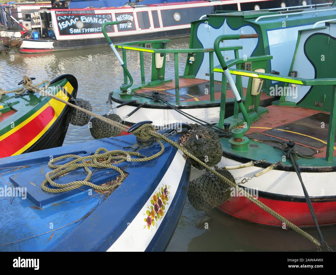 Des bateaux de étroite peints dans des couleurs vives amarrés au chemin d'attelage sur les rives du canal Grand Union, près de la marina de Braunston, dans le Northamptonshire Banque D'Images