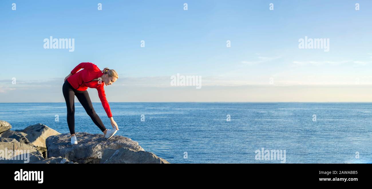 jeune femme russe qui fait de l'entraînement avec robe rouge au bord de la mer Banque D'Images