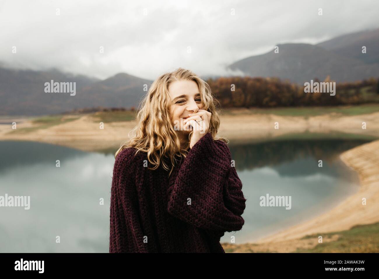 Portrait d'une belle femme romantique se tenant près du lac. Elle souriait et appréciait son temps. Banque D'Images