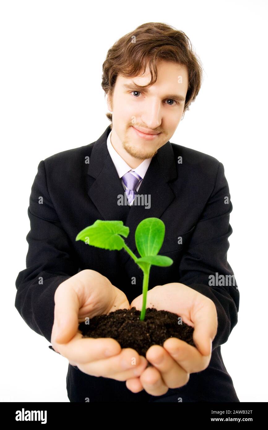 Photo d'un homme d'affaires qui garde dans ses mains un germe vert Banque D'Images