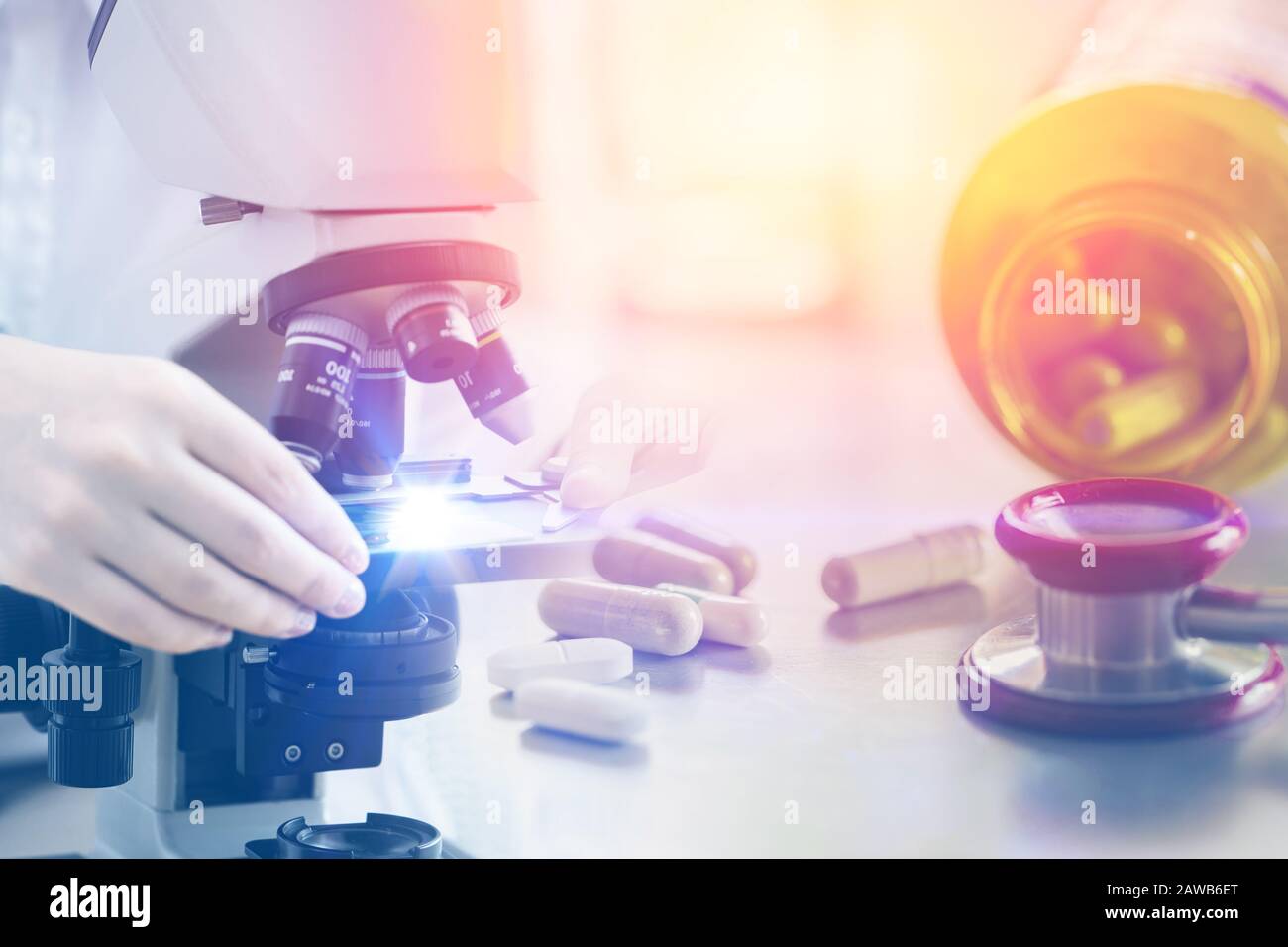 pilules de médecine avec microscope en laboratoire de recherche en sciences médicales pour le concept de l'industrie pharmaceutique Banque D'Images