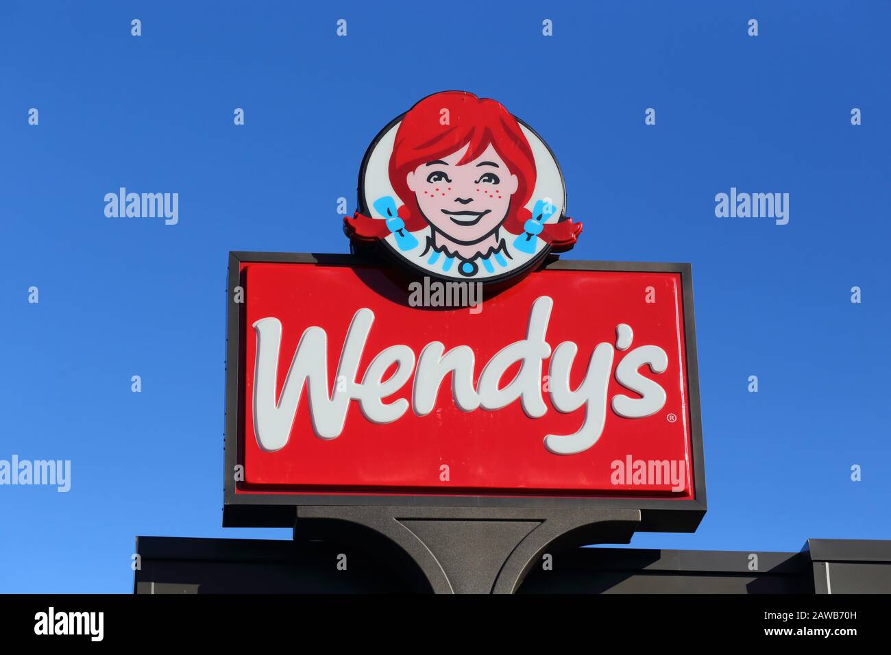 Le logo Wendy's avec un fond bleu sur un restaurant dans le Bronx, New York, NY Banque D'Images