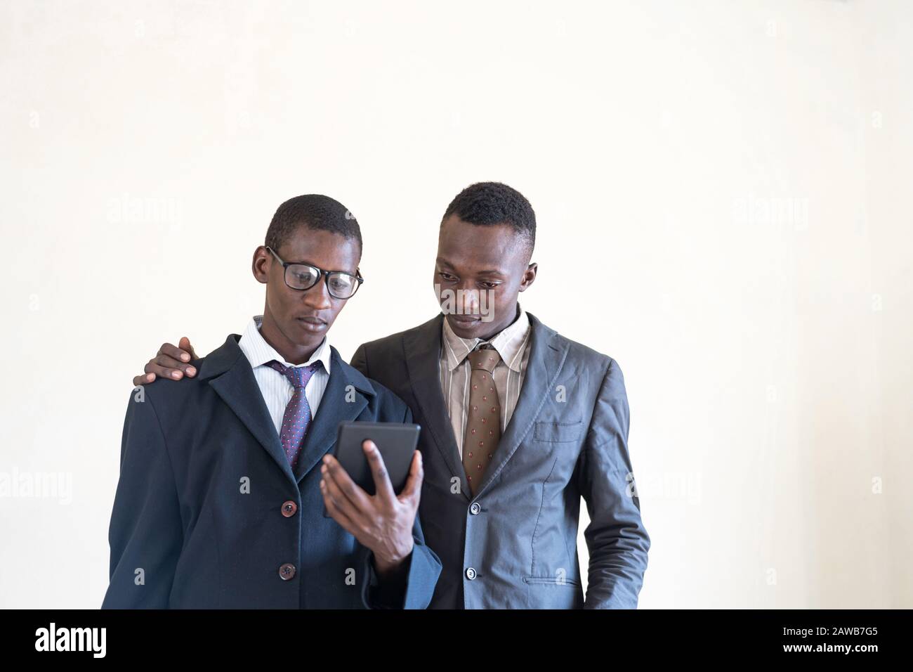 Deux Jeunes Hommes D'Affaires Noirs Travaillant Sur Tablette Dans Le Bureau Blanc Banque D'Images