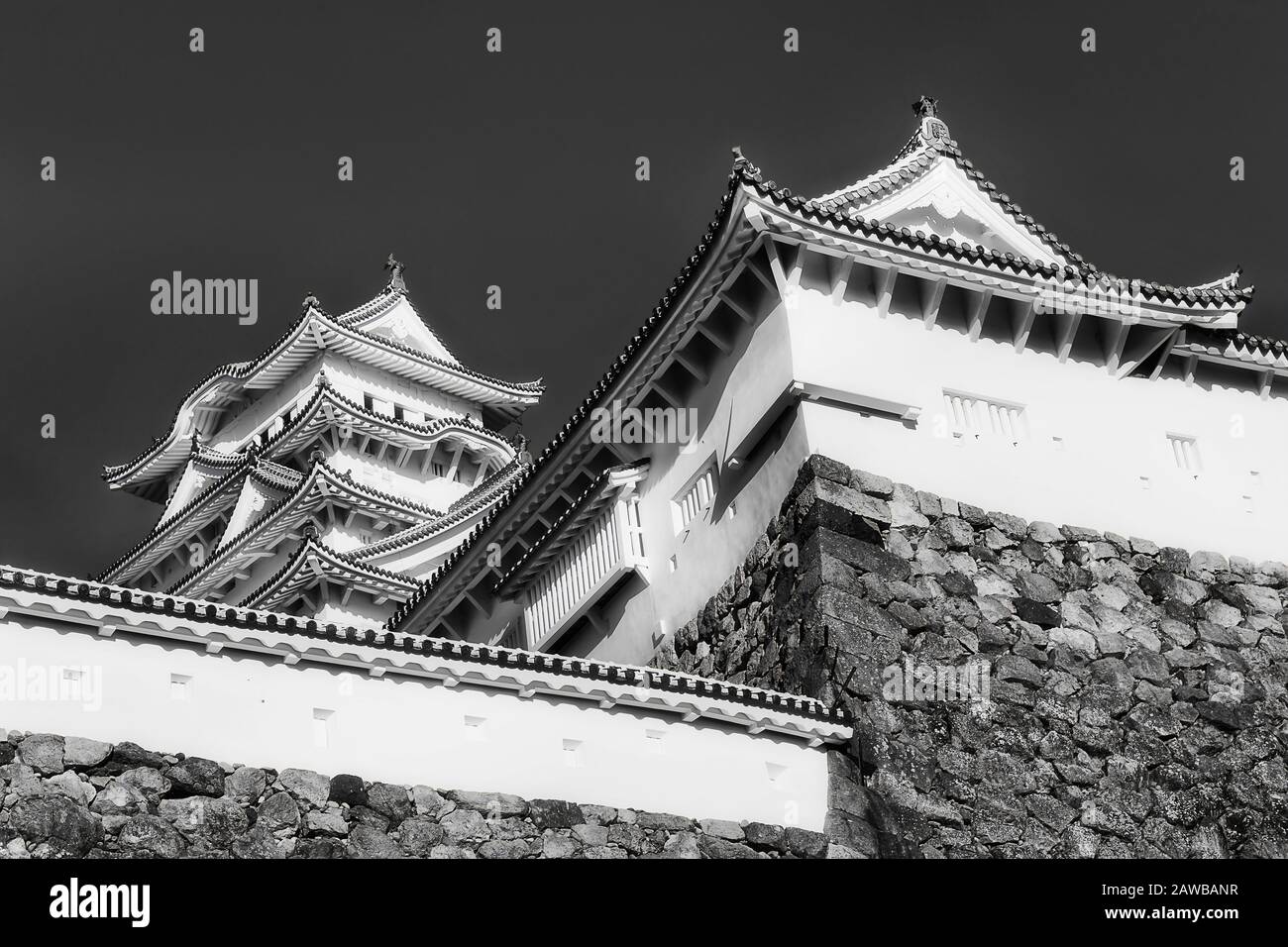 Hauts de tours historiques dans le château japonais de shogun près de la ville d'Osaka au-dessus des murs en pierre, à l'impression noir-blanc contraste. Banque D'Images
