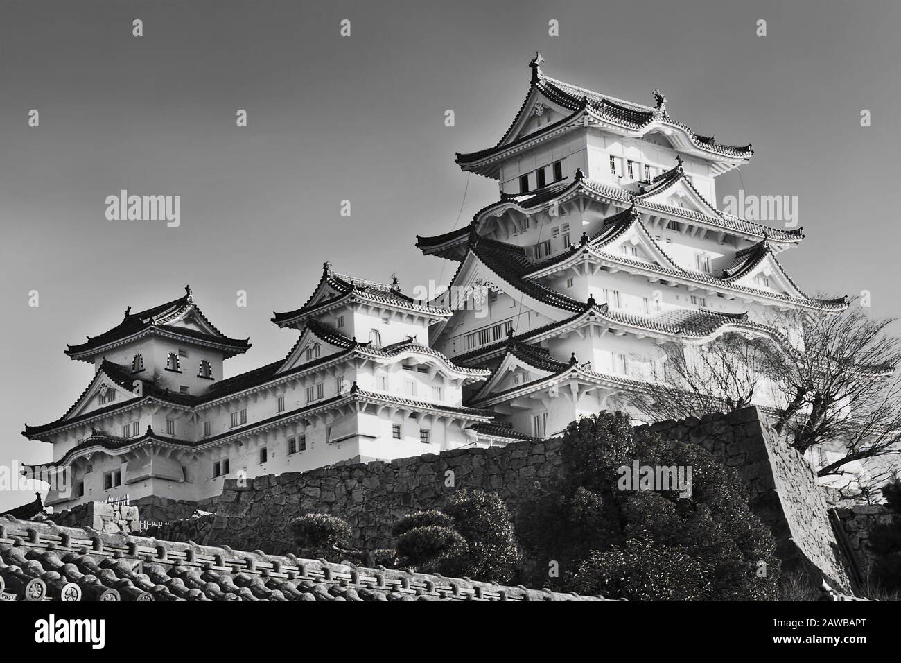 Image contraste élevé du château historique peint en blanc dans la ville japonaise Himeji sur les murs en pierre sous ciel clair. Banque D'Images