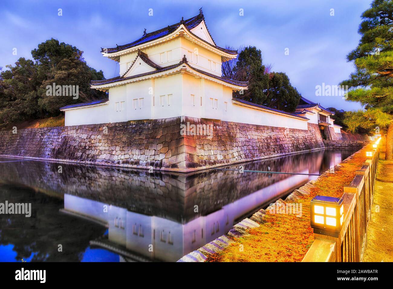 Tour de montre d'angle de mur de pierre autour du château de Nijo à Kyoto ville du Japon au lever du soleil avec éclairage de rue. Banque D'Images