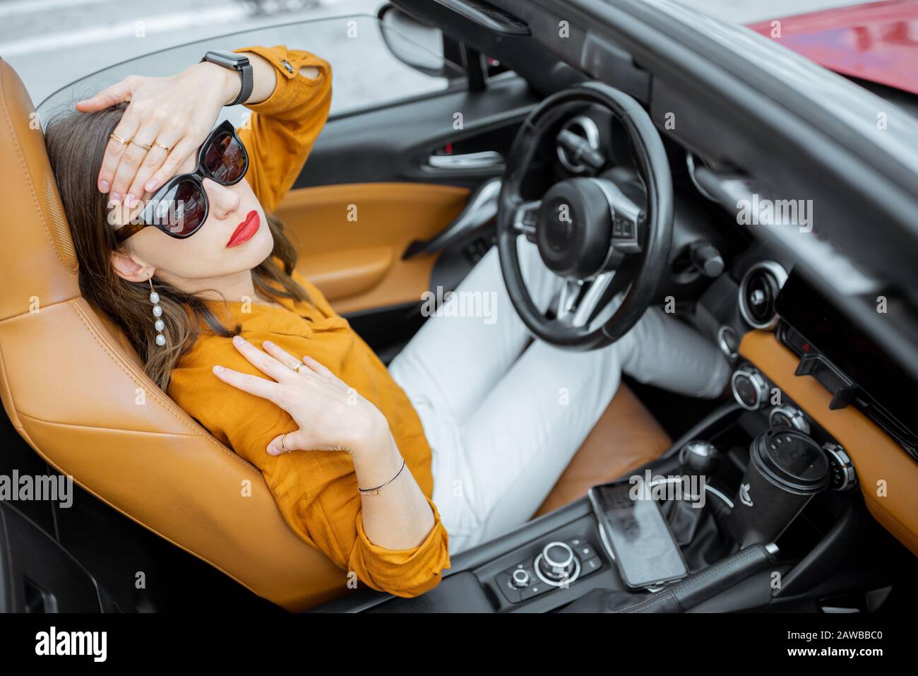 Jeune femme mal de tête lorsqu'elle est assise sur le siège conducteur de la voiture convertible. Vue de dessus Banque D'Images