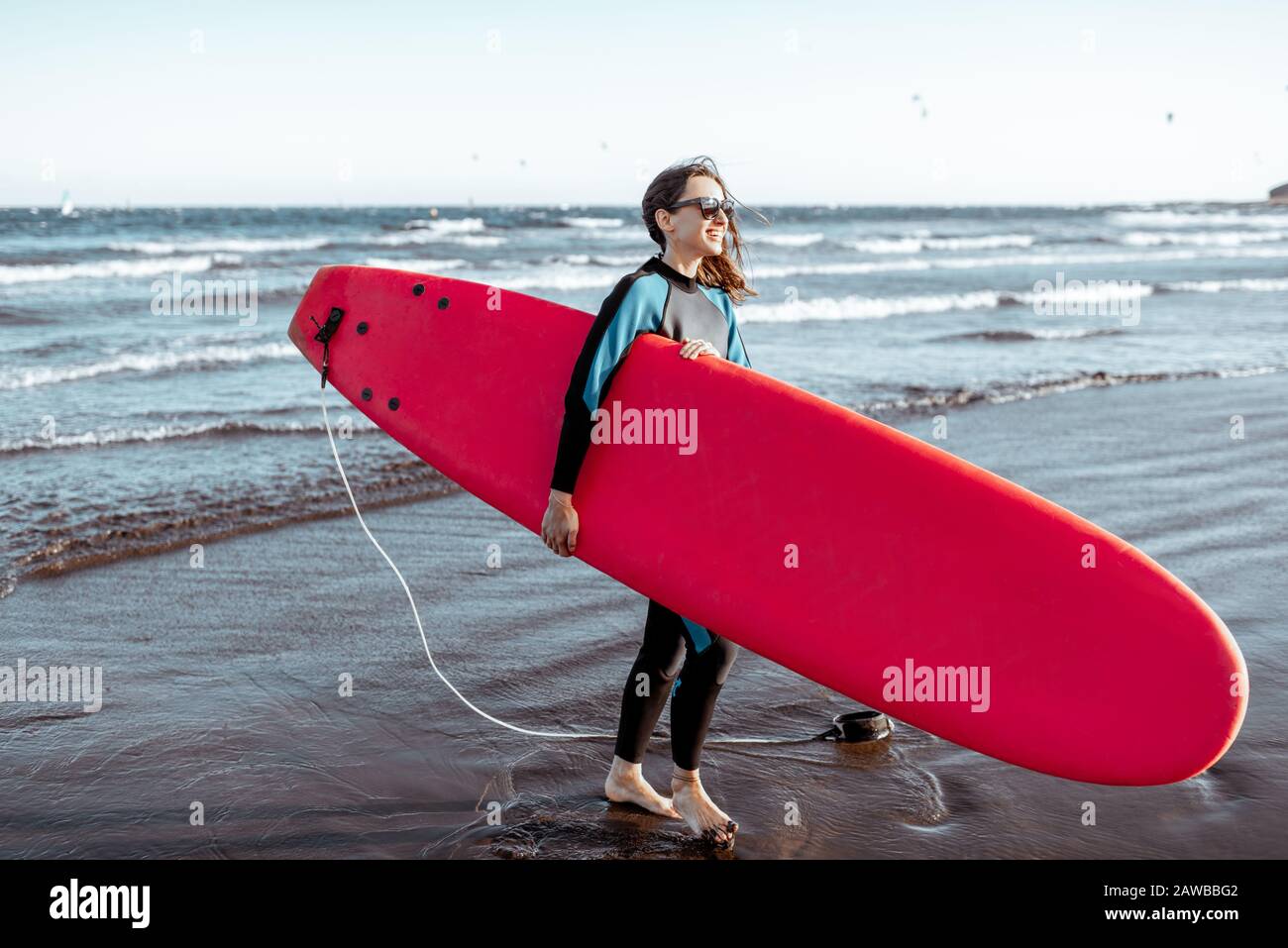 Portrait d'une jeune femme surfant en maillot de bain debout avec planche  de surf rouge sur la plage. Style de vie actif et concept de surf Photo  Stock - Alamy