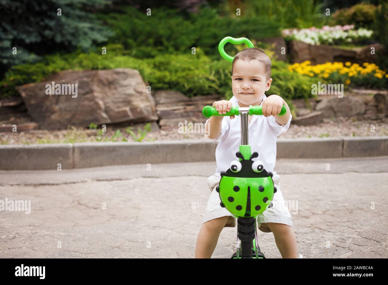 enfant garçon qui monte un trike dans le parc Banque D'Images