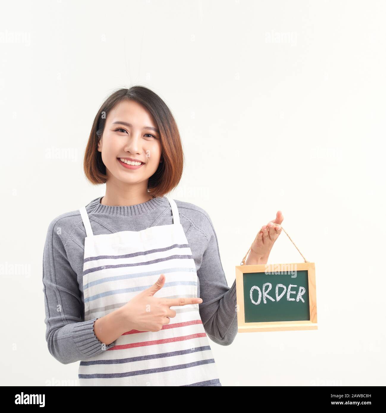 Gai fille tenant le panneau de publicité avec le mot de commande et de pointage sur lui, fond de studio blanc Banque D'Images