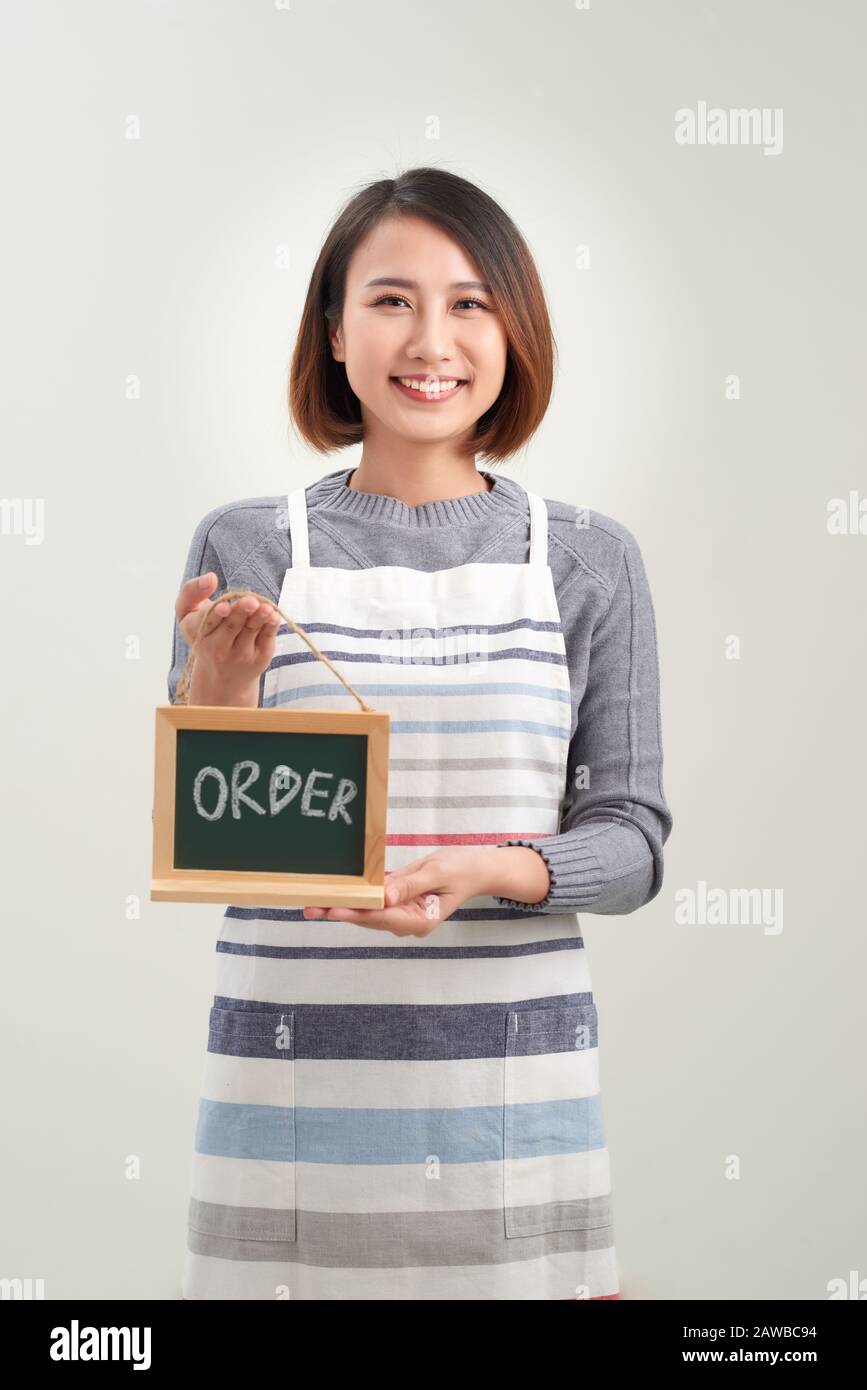 Jeune barista asiatique tenant un menu de tableau de surveillance en blanc Banque D'Images
