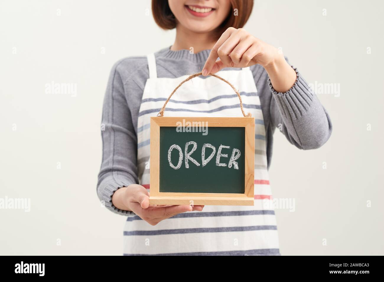 Portrait d'une serveuse souriante montrant un tableau de surveillance avec un panneau de commande en blanc Banque D'Images