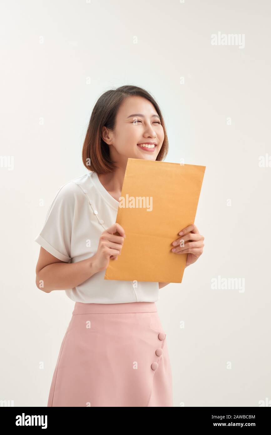 Jeune femme asiatique tenant une enveloppe marron auto-scellée sur fond blanc Banque D'Images