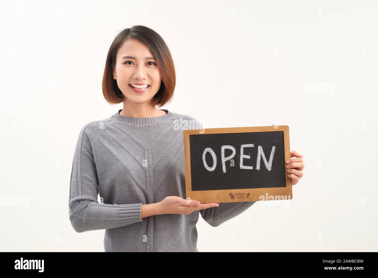 Portrait du jeune beau propriétaire de café asiatique tenant un signe ouvert Banque D'Images