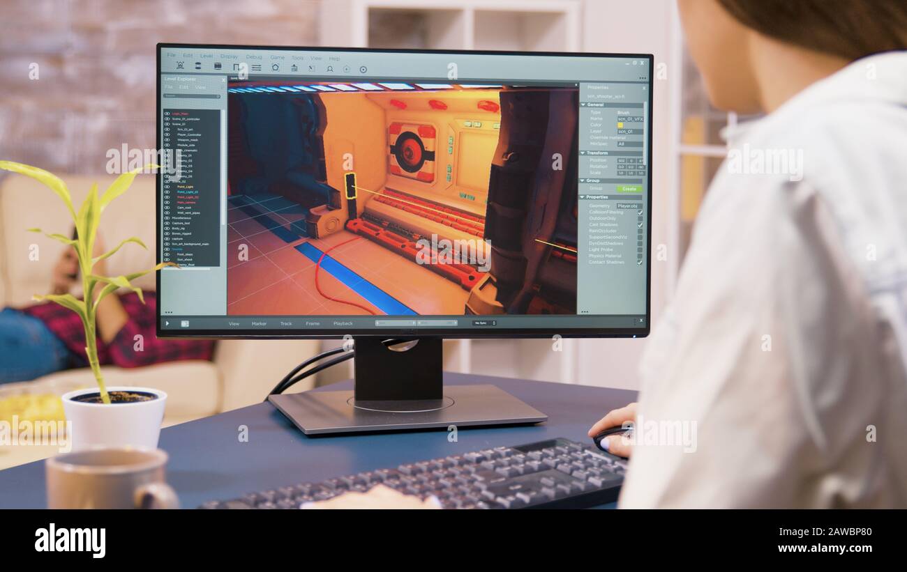 Gros plan de la jeune femme développeur de jeux travaillant sur un nouveau niveau de jeu vidéo dans sa maison Banque D'Images