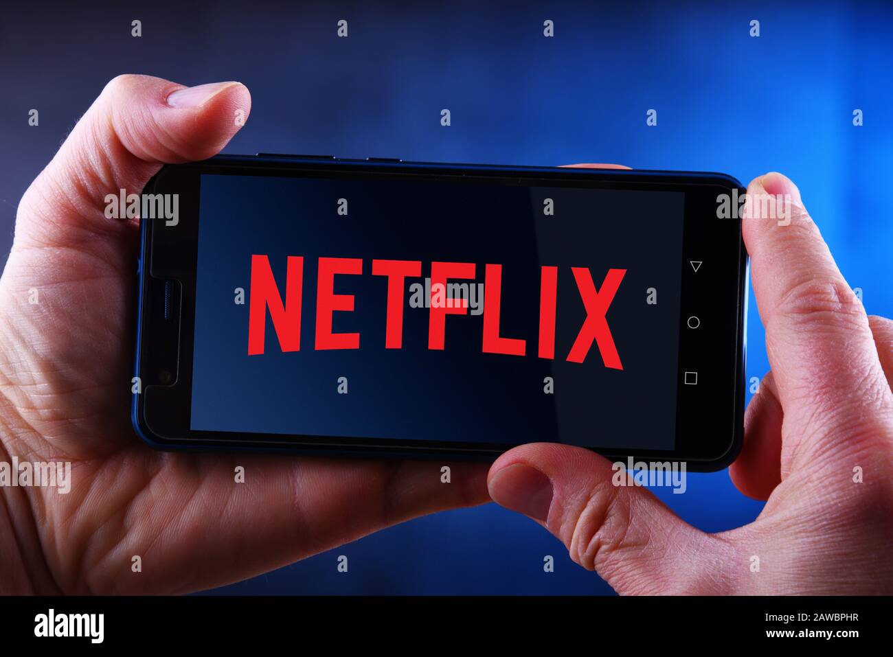 Poznan, POL - 24 MARS 2019: Main tenant smartphone affichant le logo de Netflix, un fournisseur américain de services de médias dont le siège social se trouve à Los Gatos, Californie Banque D'Images