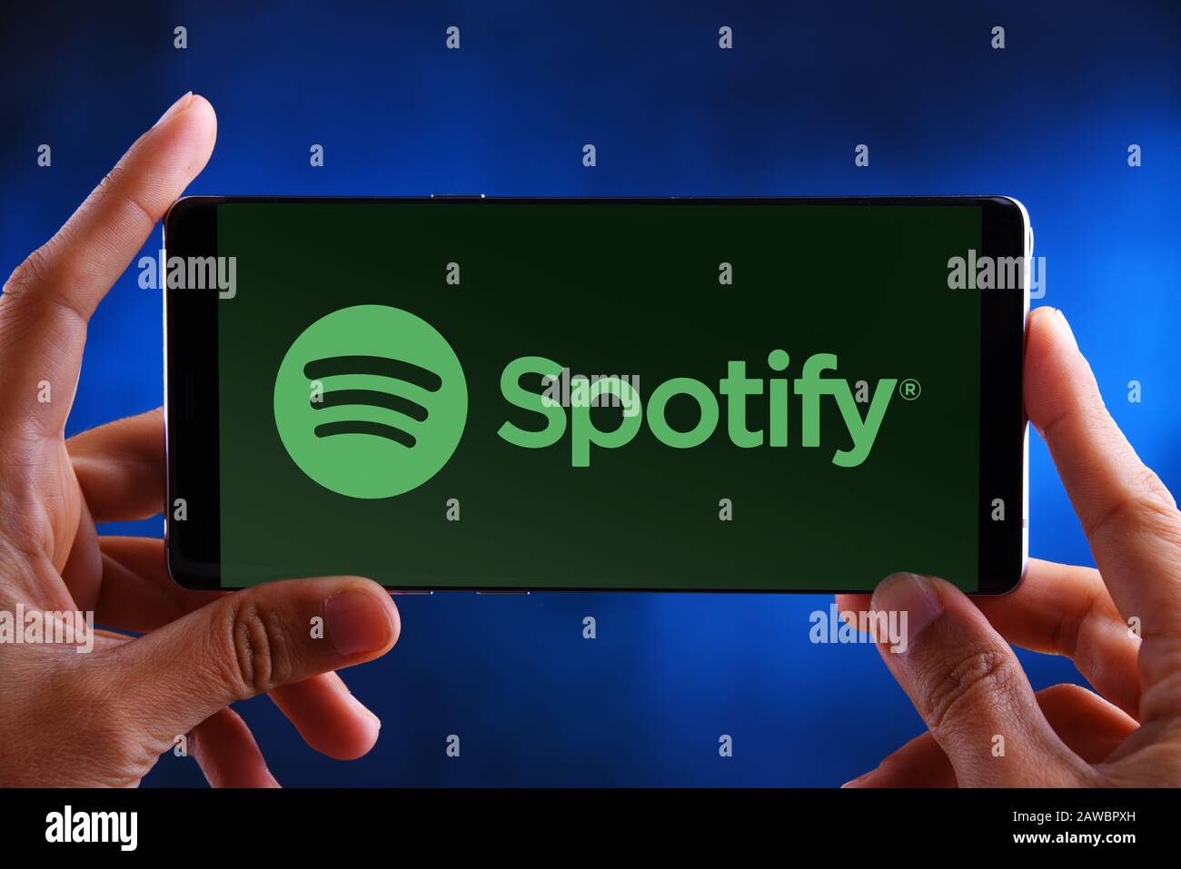 Poznan, POL - 10 JUILLET 2019 : un smartphone avec les mains portant le logo de Spotify, une plate-forme de diffusion audio suédoise qui fournit de la musique et des podcasts f Banque D'Images