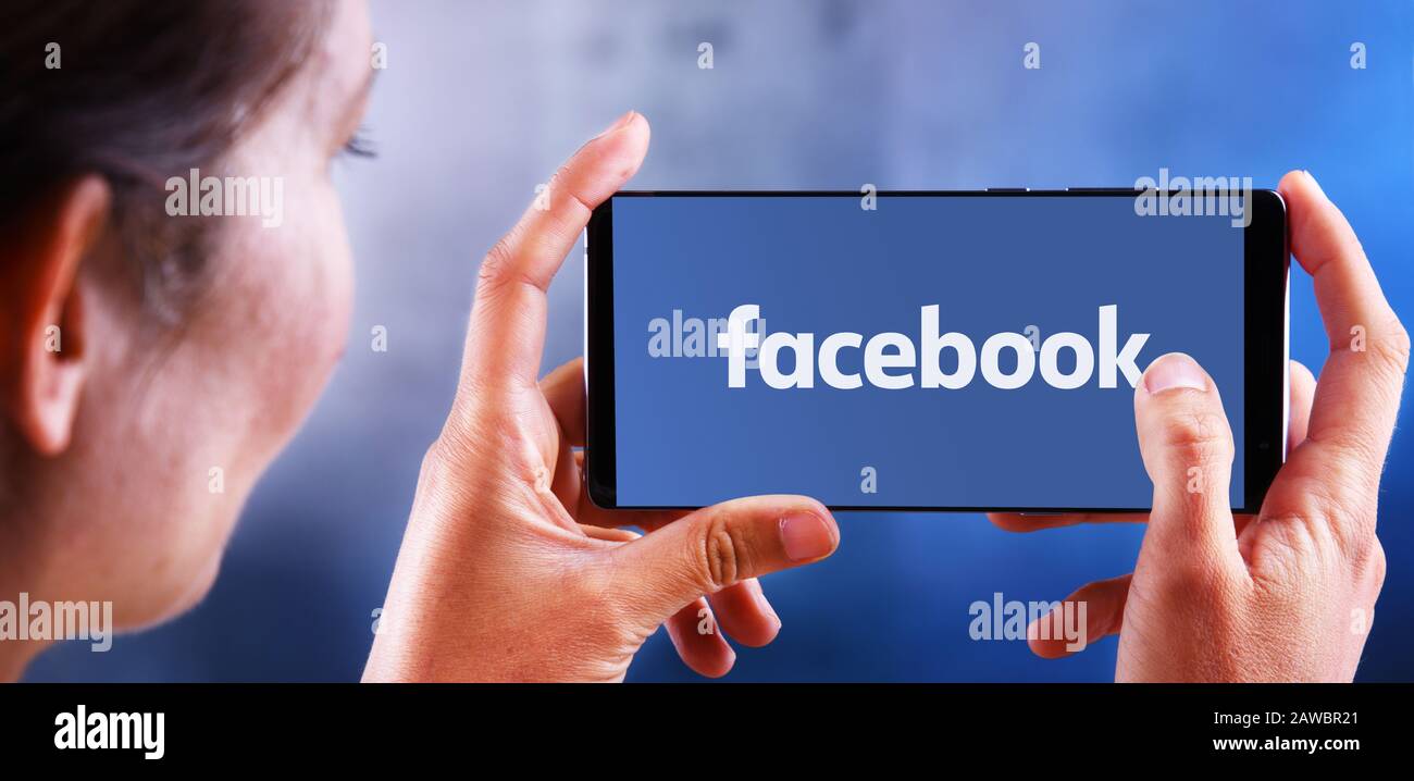 Poznan, POL - 10 JUILLET 2019: Femme tenant smartphone affichant le logo de Facebook, un compan américain de réseaux sociaux et de réseaux sociaux en ligne Banque D'Images