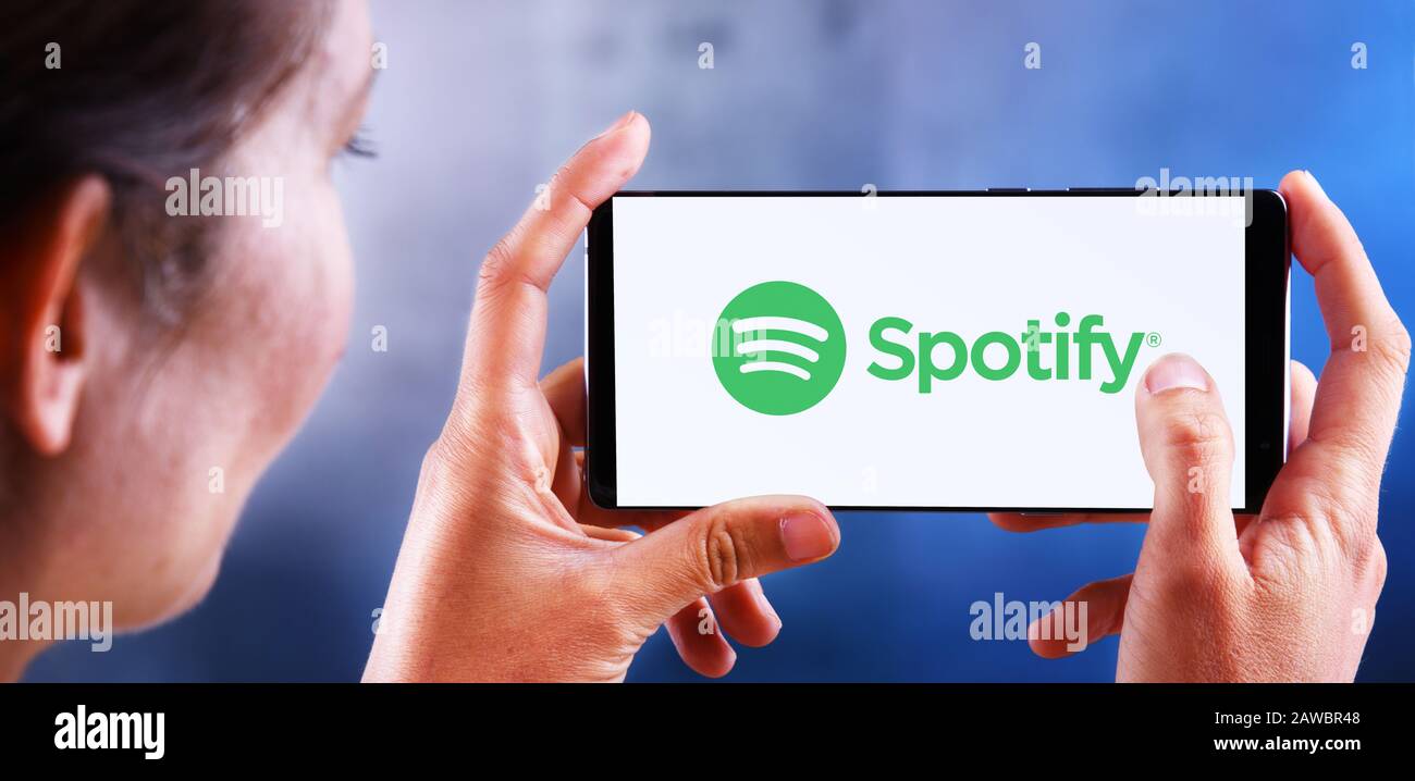 Poznan, POL - 10 JUILLET 2019 : femme tenant son smartphone avec le logo Spotify, une plate-forme de diffusion audio suédoise qui fournit de la musique et des podcasts f Banque D'Images
