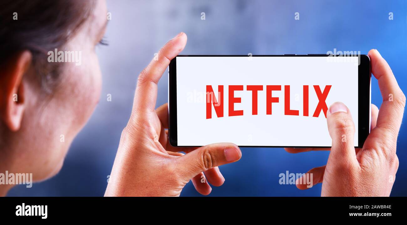 Poznan, POL - 10 JUILLET 2019 : femme tenant un smartphone portant le logo de Netflix, un fournisseur américain de services de médias dont le siège social se trouve à Los Gatos, Californie Banque D'Images