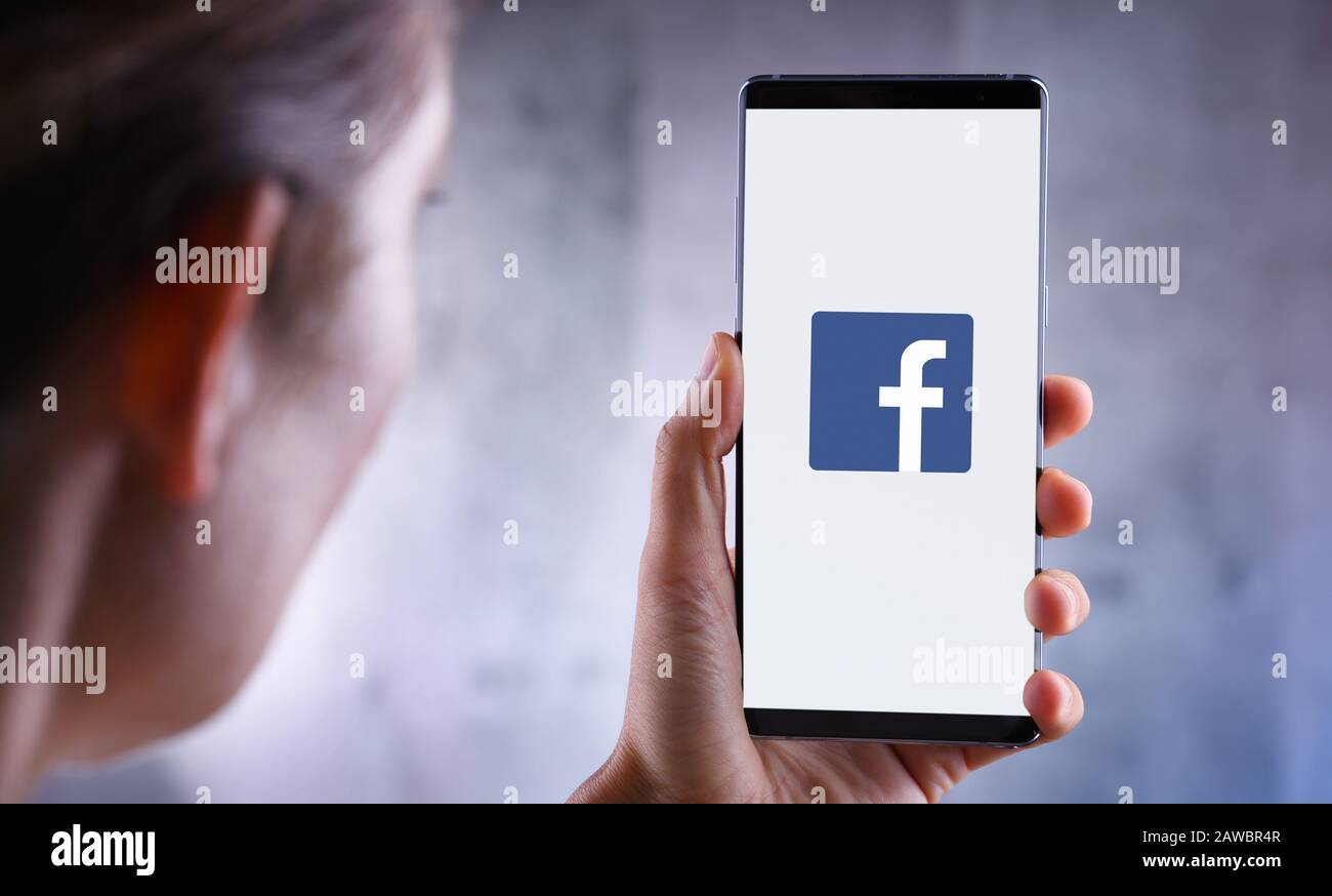 Poznan, POL - 10 JUILLET 2019: Femme tenant smartphone affichant le logo de Facebook, un compan américain de réseaux sociaux et de réseaux sociaux en ligne Banque D'Images