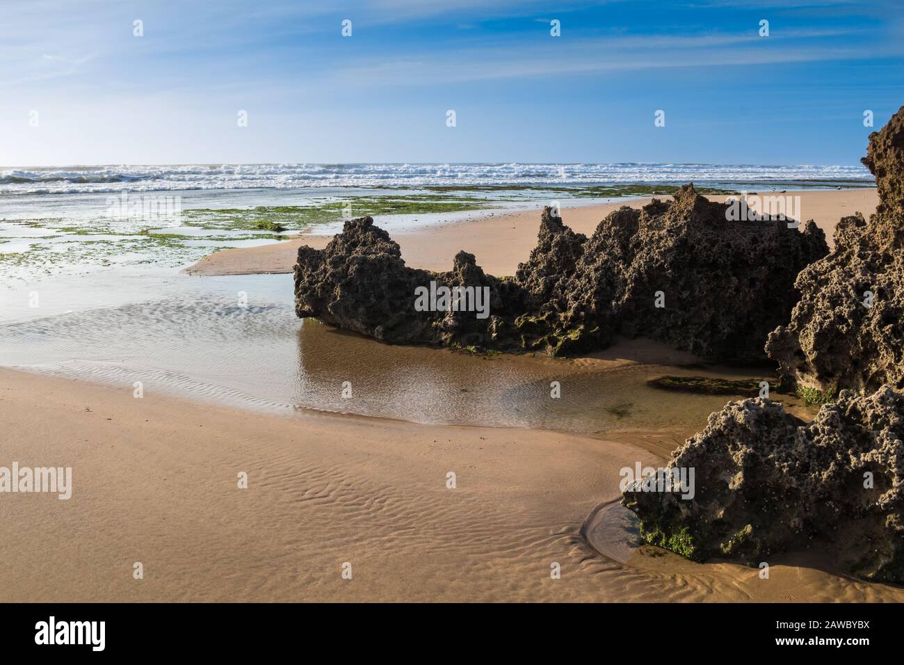 Côte de l'océan Atlantique avec sable et rochers. Après-midi tardif avec ciel nuageux. Moulay Bouzerktoun, Maroc. Banque D'Images