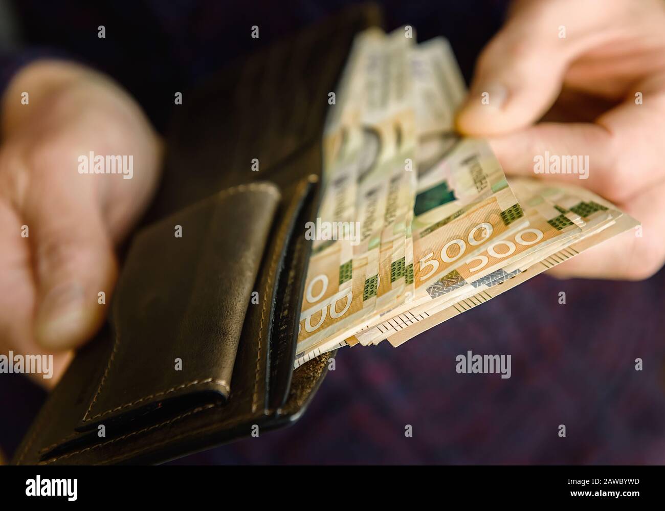 Portefeuille en cuir marron avec billets sur une ancienne surface en bois. Gros plan. Banque D'Images