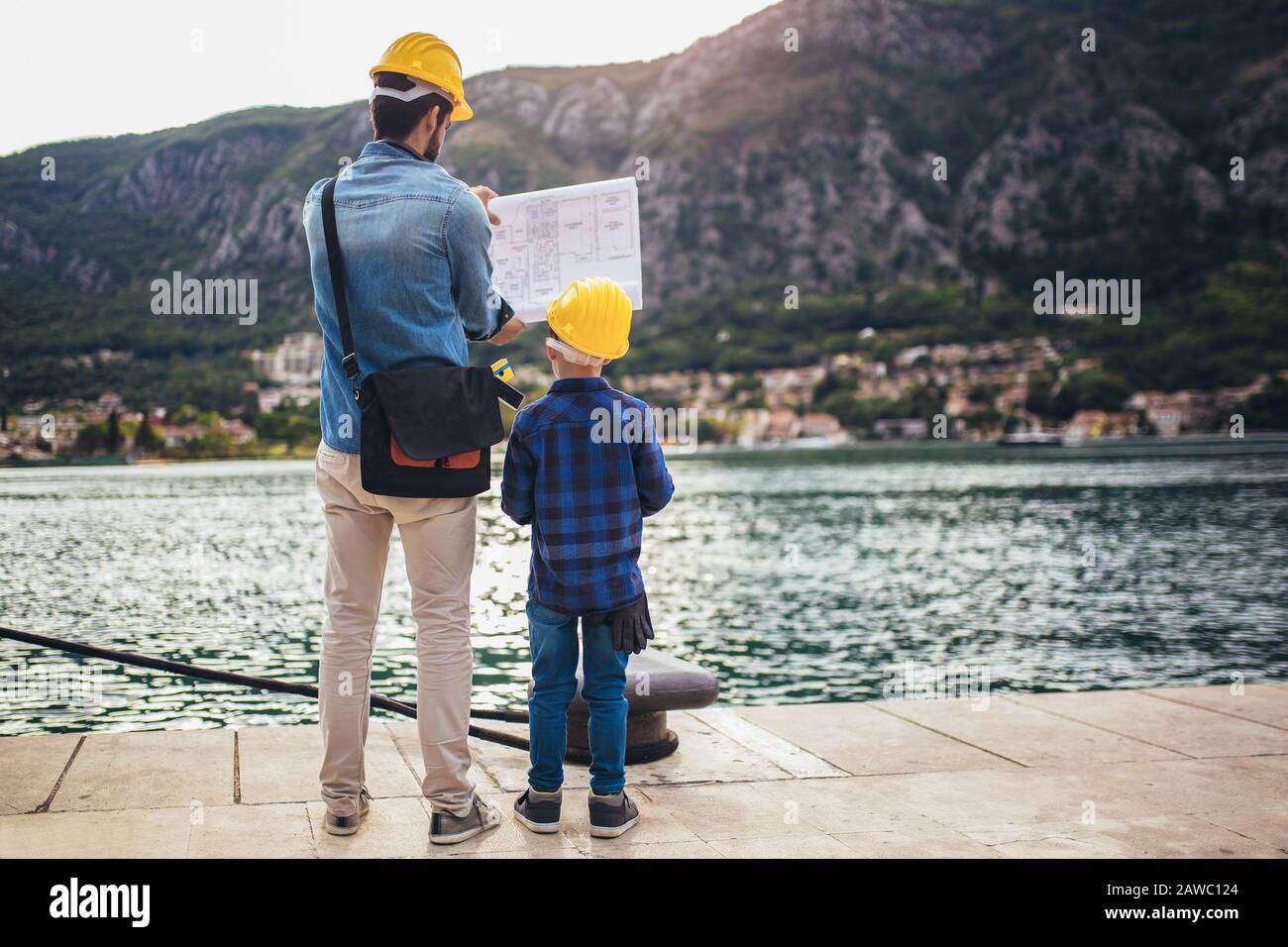 Ingénieur de port avec son fils tenant le papier, travaux de construction, sourire. Banque D'Images