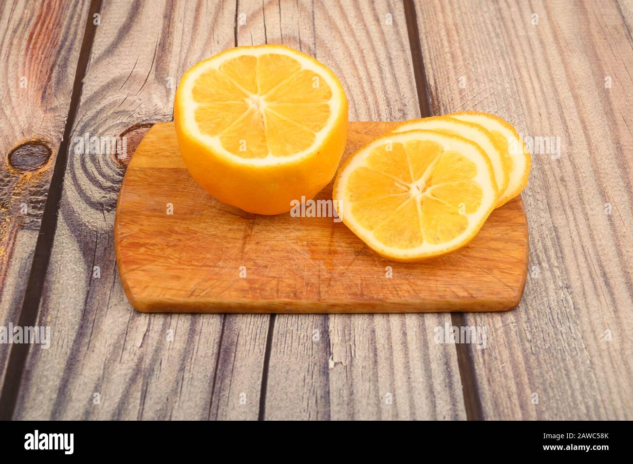 Citron jaune mûr en tranches sur un fond de bois. Gros plan Banque D'Images